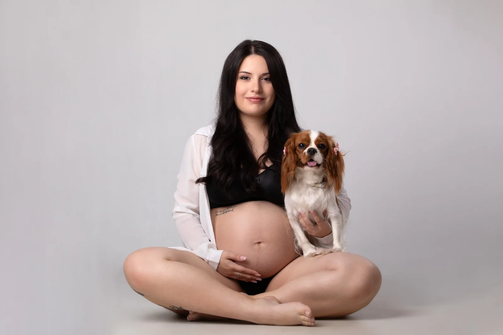 Fotografie in gravidanza con cagnolina - momento tenero nello studio di Milano