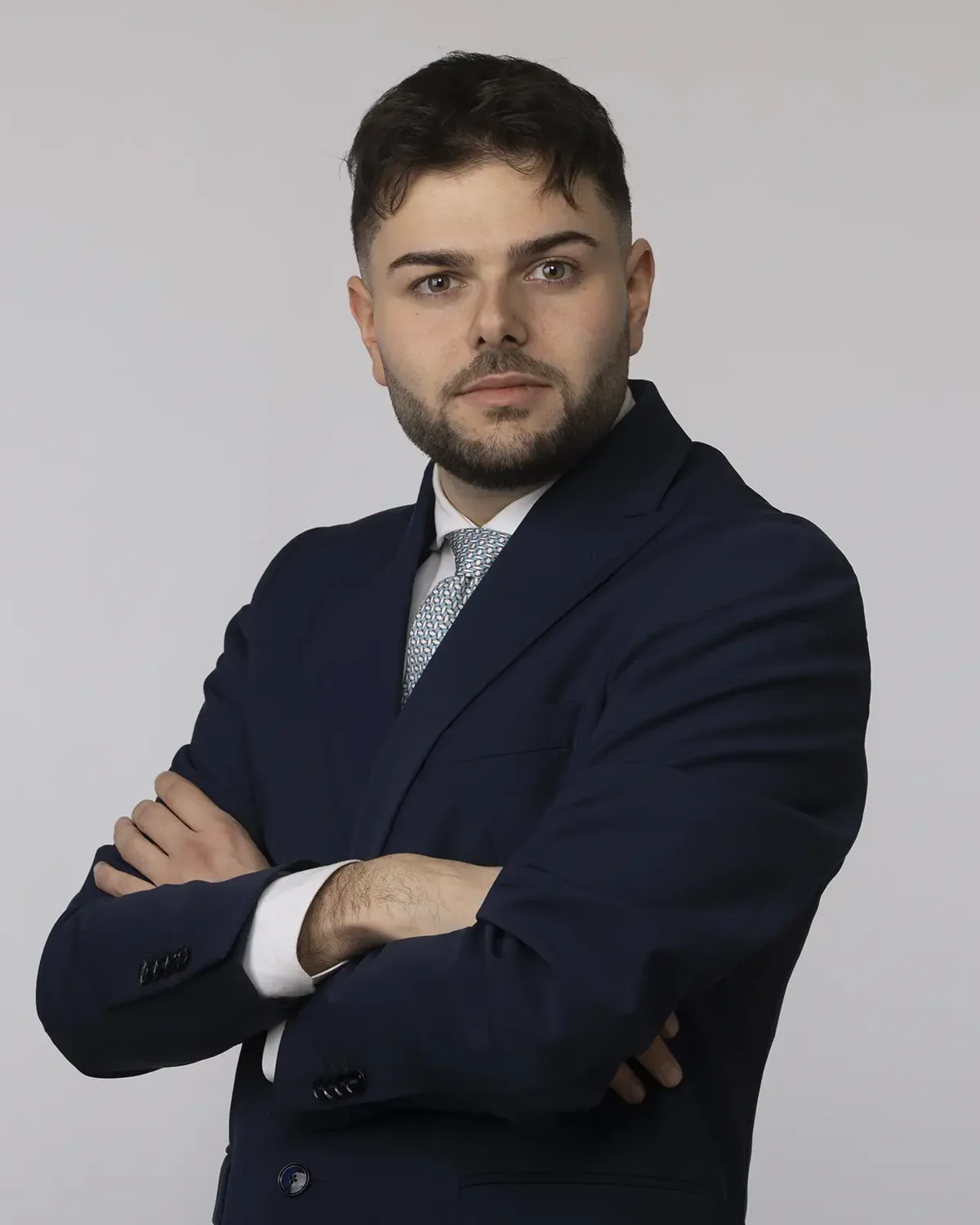 Ritratto professionale uomo con barba, abito blu e cravatta chiara, foto LinkedIn Milano