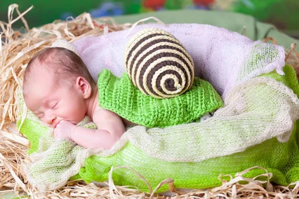 Neonato avvolto in tessuti morbidi, fotografia newborn in studio Milano