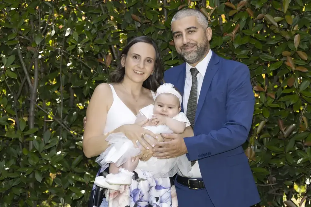 Famiglia al completo dopo il battesimo, foto in esterna con sfondo di foglie, Milano