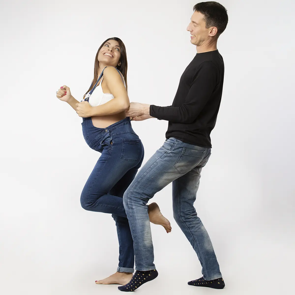 Coppia in attesa durante un book fotografico gravidanza a Milano, momento di complicita e risate in studio