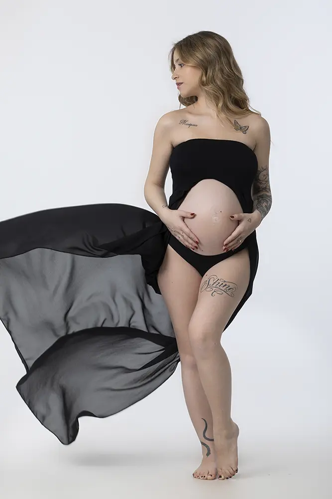 Futura mamma con velo nero in movimento durante un book fotografico gravidanza fine art in studio a Milano