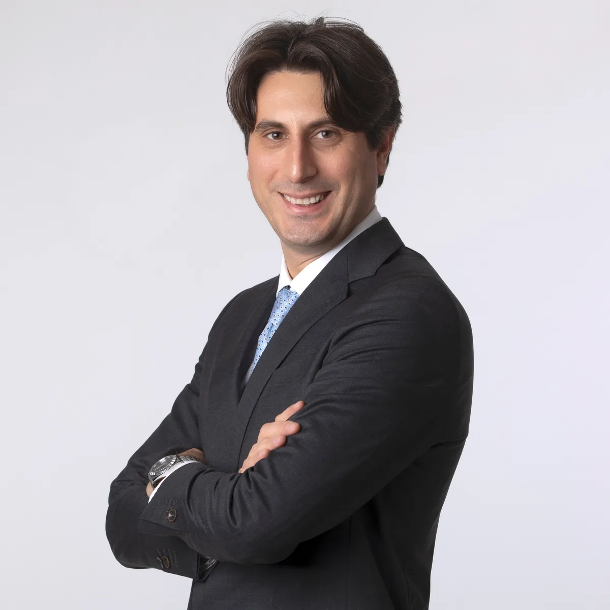 Ritratto professionale di un uomo sorridente con cravatta azzurra, studio a Milano